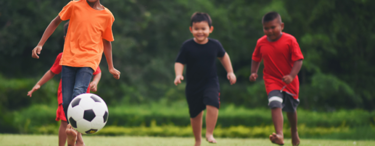 Children playing soccer 910x690